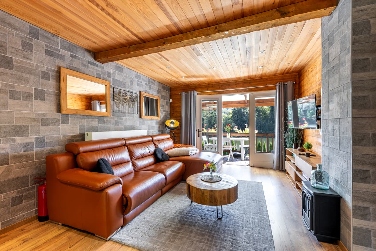 Chalet living room with a leather sofa and a glazed door to the terrace