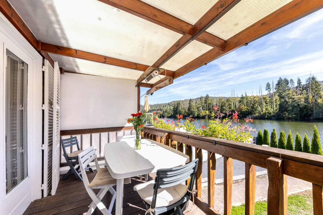 Covered terrace with a table, a view of the river