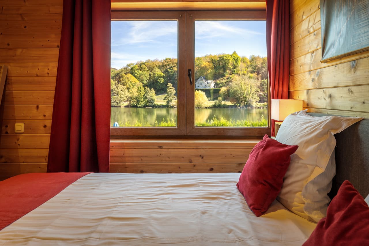 Bedroom window onto the Meuse, between the red curtains