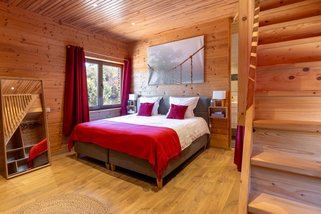 Wood bedroom with a red throw, at the foot of the stairs