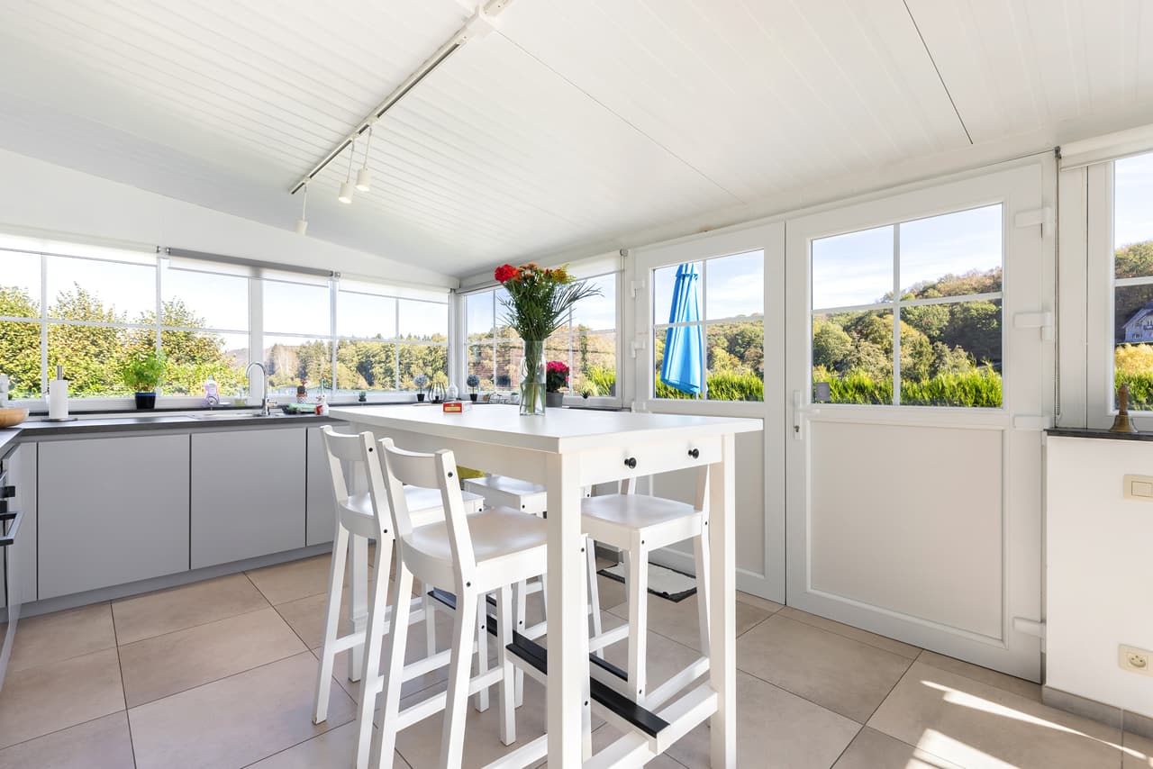Kitchen veranda with a high table and large windows