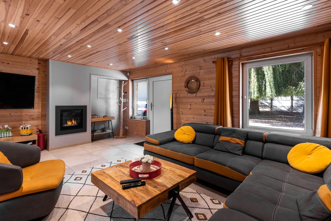 Living room with an inset fire, a dark sofa and a window