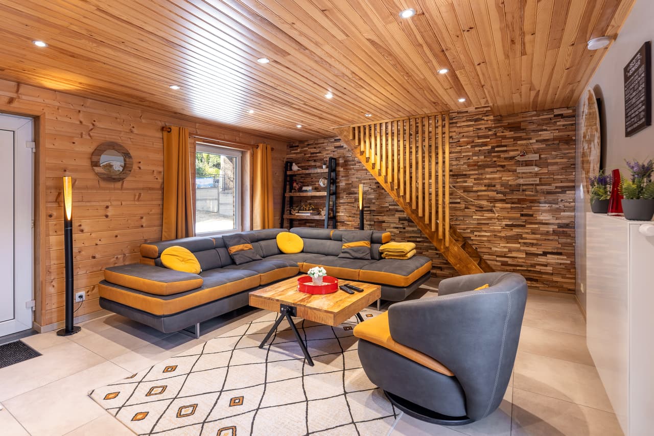 Living room with a corner sofa, an armchair and a wooden staircase
