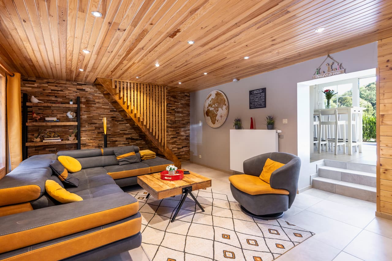 Living room open to the kitchen, grey armchair and staircase