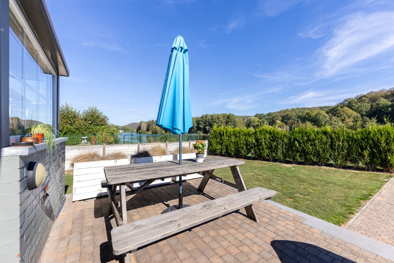 Terrace with a picnic table and a blue parasol
