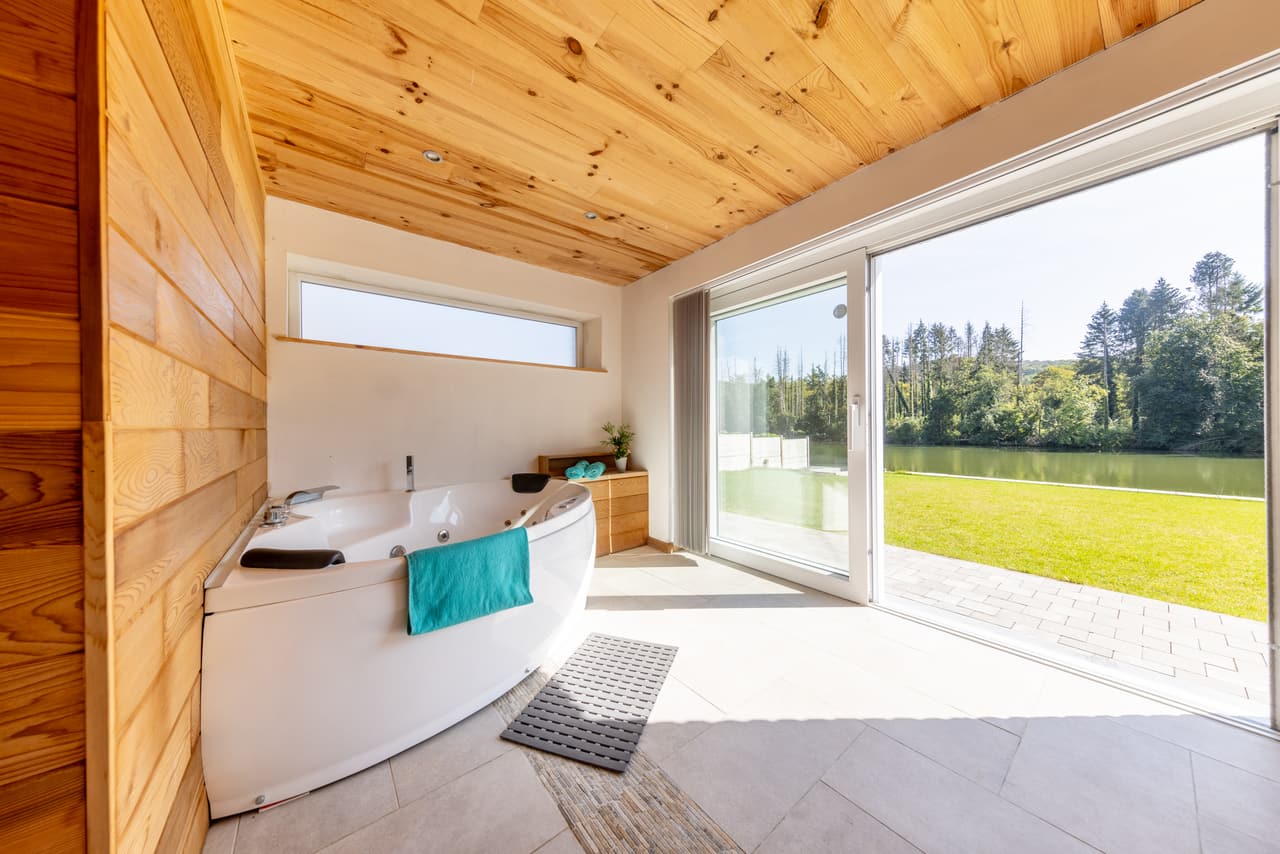 Whirlpool bath and a glazed opening onto the garden and the Meuse