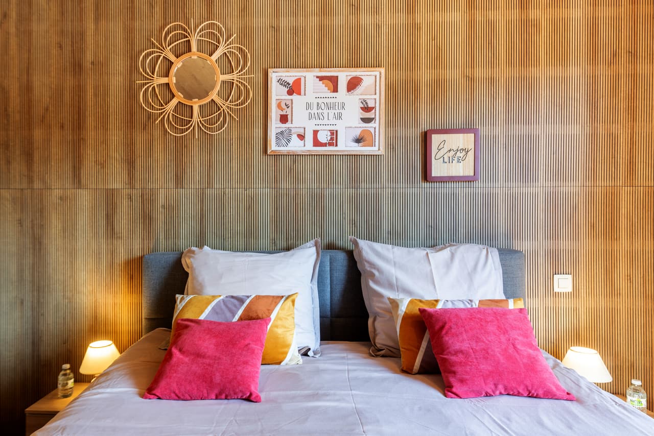 Pink cushions and the wood wall of the wood-panelled bedroom