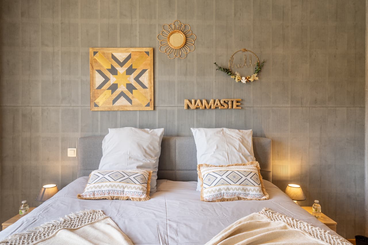 Head of the bed in the grey bedroom, against the fluted wall