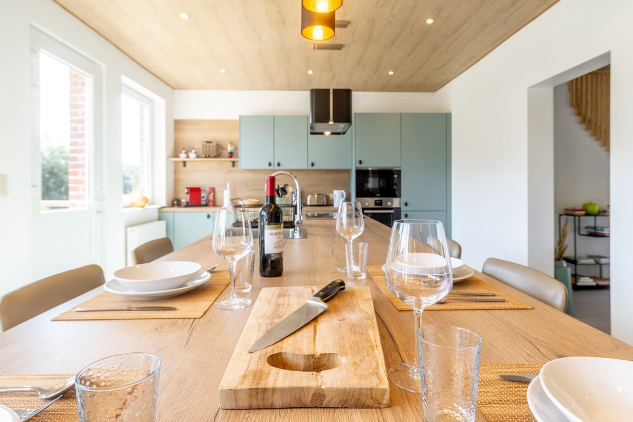 Table laid along its length, facing the sage-green cabinets