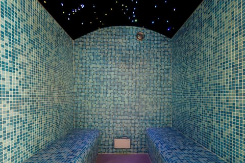 Hammam lined in blue-green mosaic, with a starry ceiling