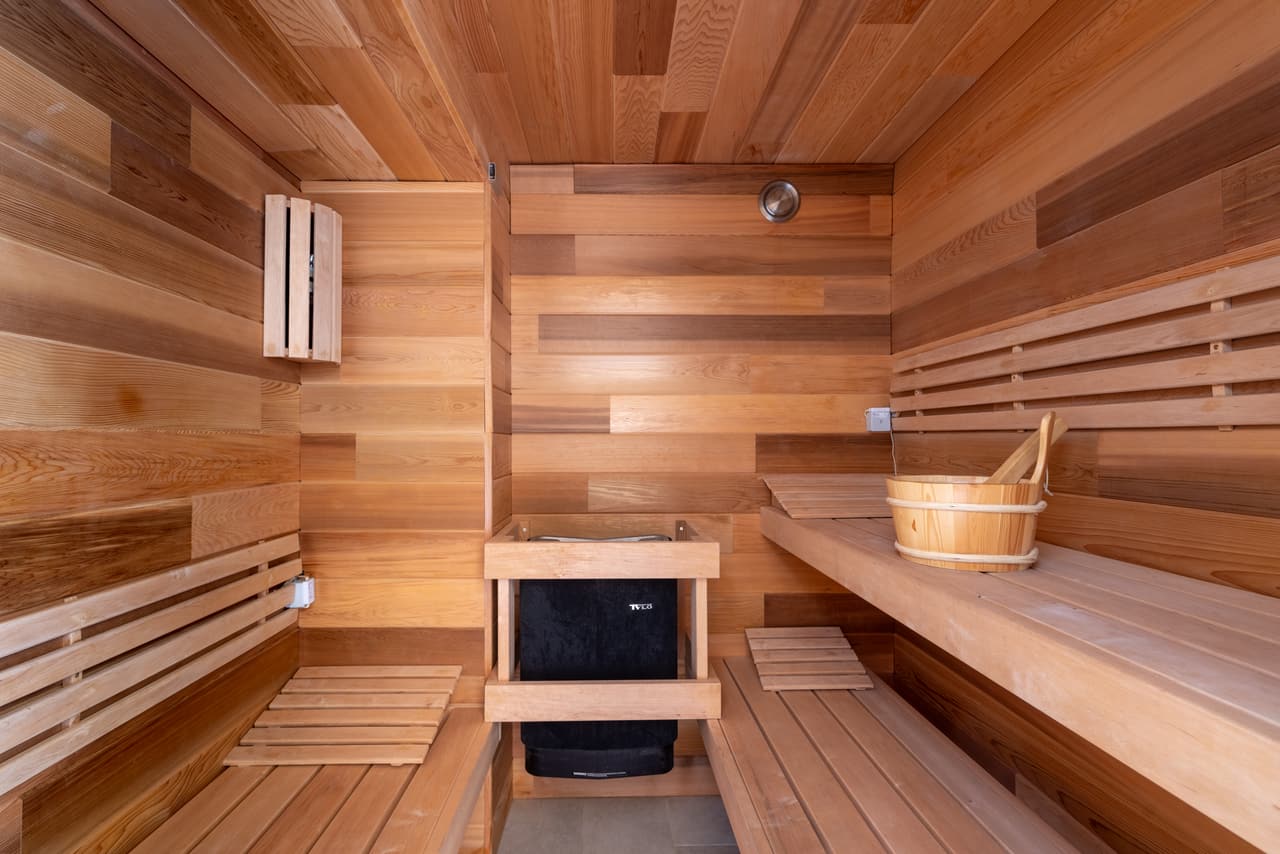 Wooden sauna with a stove and bucket