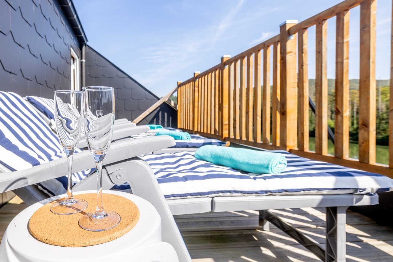 Sun-terrace lounger with two glasses, facing the Meuse