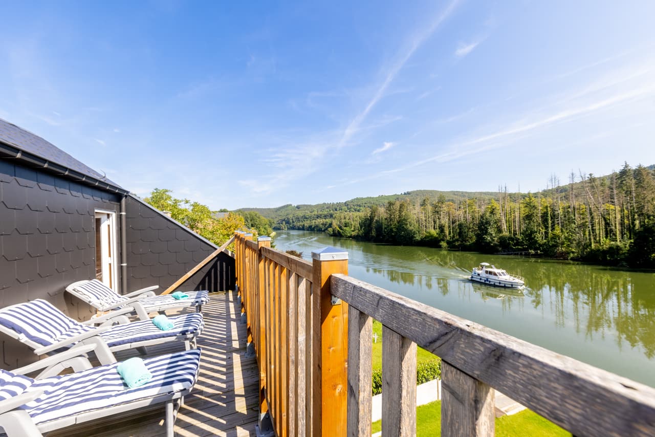 Sun terrace like a balcony over the Meuse, a boat in the distance